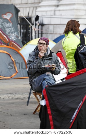 LONDON - NOVEMBER 1: Protestor with a plate of hot meal at the Occupy London Stock Exchange anti-capitalist protest on November 1, 2011 at St Paul\'s Cathedral churchyard in London, England.
