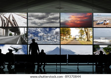 Silhouette of passengers at a waiting lounge in a transportation hub facing an advertisement panel frames showing various seasonal landscape and mode of transportation.