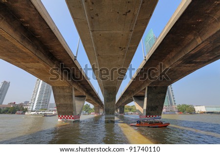 View of the triple concrete ramp of Taksin Bridge crossing the Chao Phraya River from the Sathorn Taksin ferry pier. This is a HDR image.