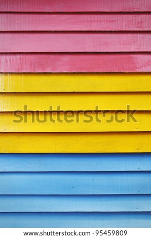 Timber plank wall painted with red, yellow and blue color paint.