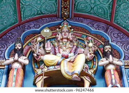 Colorful statue of the Hindu god with multiple head and arm known as Brahma on an ornate worship altar.