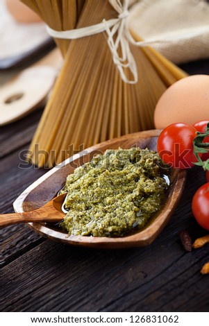 Italian cooking with whole wheat pasta, pesto sauce and ingredients