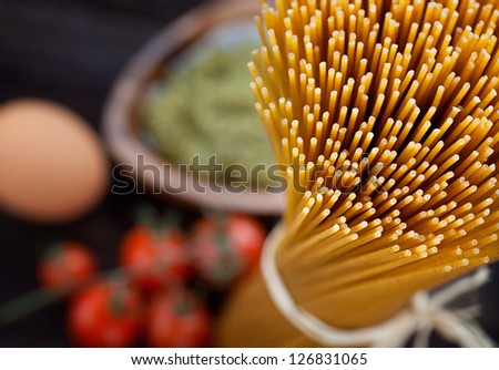 Italian cooking with whole wheat pasta, pesto sauce and ingredients