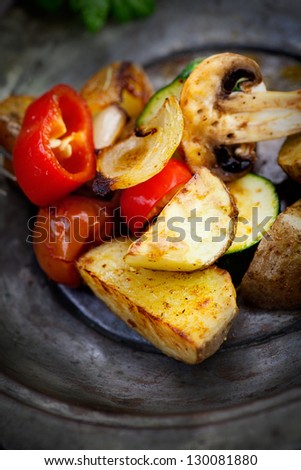 Vegetarian cooking. Organic roasted baked vegetables in vintage setting. Potatoes, paprika, mushrooms, onion, zucchini and herbs