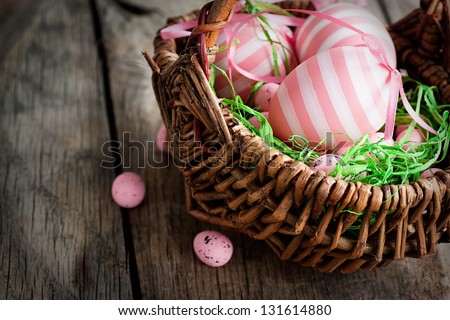 Colorful Easter holiday concept with pink eggs in wisker basket in nature