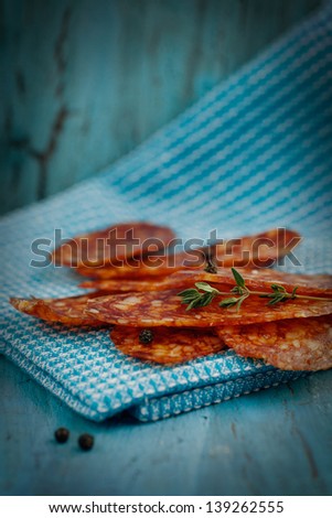 Chorizo salami sausage on blue rustic background. Meat cold cuts.