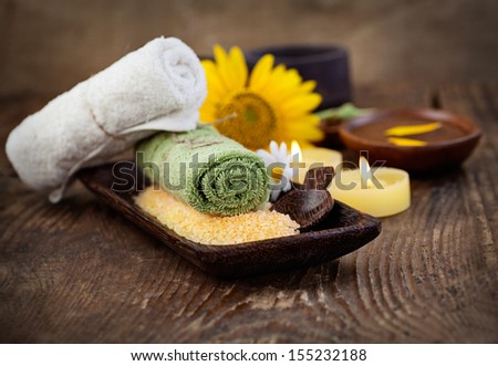Spa and wellness setting with natural bath salt, candles and towel, massager and sunflower.. Brown dayspa nature set with copyspace