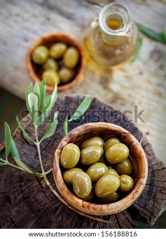 Fresh Olives And Olive Oil On Rustic Wooden Background. Olives In Olive Wood.
