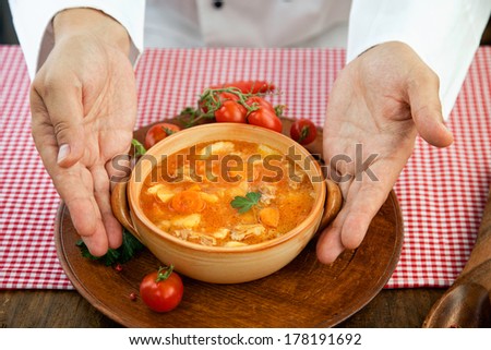 Hotel restaurant concept. Chef is finishing presenting stew dish with spices and garnish