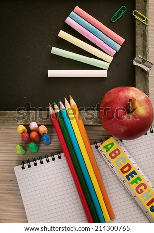 School objects for students. Chalkboard, pencils, crayons and apple
