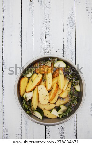 Raw potatoes. Preparation of potatoes with spices. Potatoes on wood.