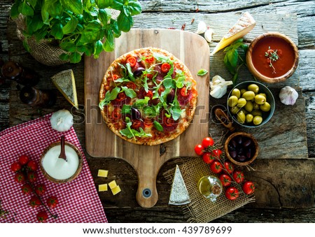 Fresh italian  pizza on wood. Pizza with cheese, salami and tomatoes. Fast food. Rustic pizza
