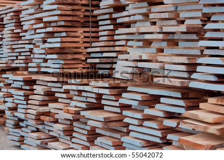 Stacked pile of painted deck boards in a lumber yard.
