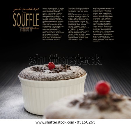Chocolate souffle with chocolate chips and red currant and copyspace isolated on black background.