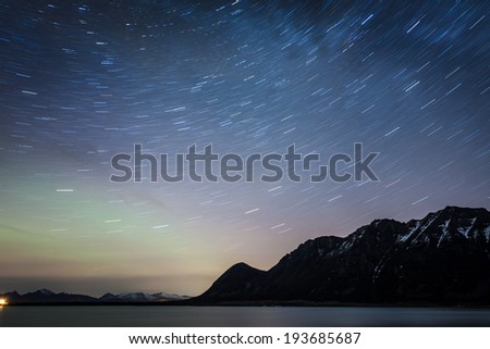 startrail landascape of mooving stars over the sea in norway