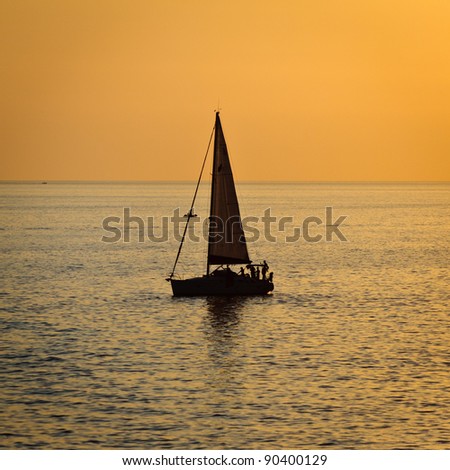 vessel  surfing the water in backlight, at sunset, in south italy