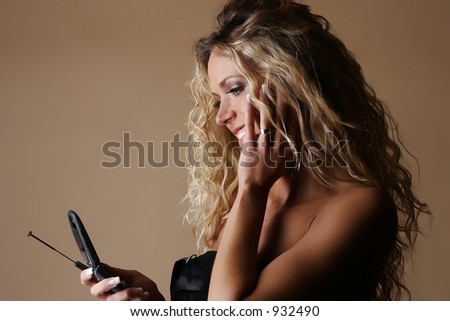 Female model smiling while looking at cell phone screen