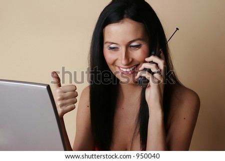 Female smiling speaking with support on cell phone while looking at laptop screen