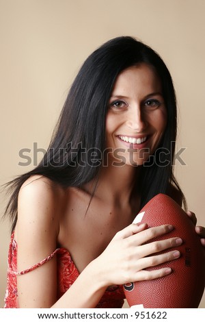 Brunette Female smiling holding a football
