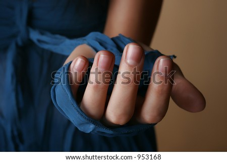 Female hand wrapped in a piece of blue dress