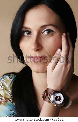 Female wearing a watch and touching her face