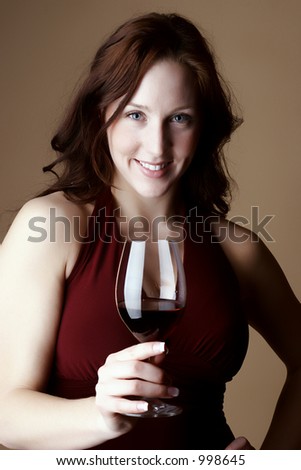 Red hair female smiling and holding a glass or red wine