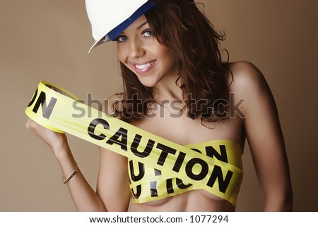 Nude female smiling, wearing a construction hard hat and with breasts covered by yellow \