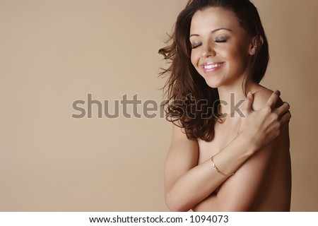 stock photo Nude female smiling with eyes shut and covering body with 
