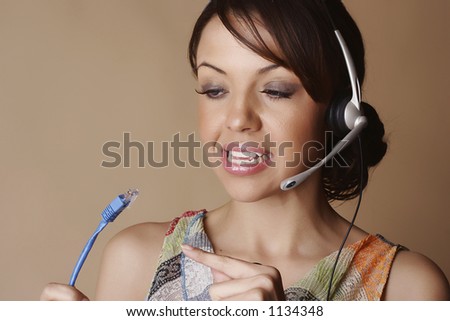 Female wearing a headset and pointing to a network cable