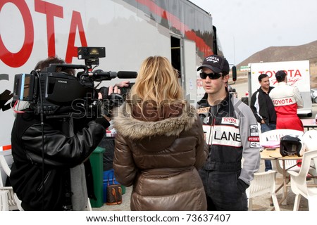 LOS ANGELES - MAR 19:  Extra Interviewing Kevin Jonas at the Toyota Pro/Celebrity Race Training Session at Willow Springs Speedway on March 19, 2011 in Rosamond, CA