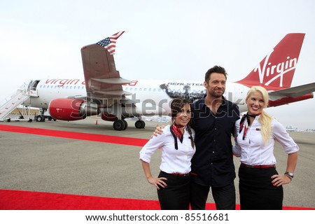 LOS ANGELES - SEPT 23:  Hugh Jackman with Virgin America flight attendants arrives as Virgin America unveils new DreamWorks \'Reel Steel\' plane at LAX Airport on September 23, 2011 in Los Angeles, CA