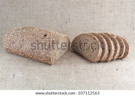 Bread from wheat flour and bran against the background of burlap tablecloth