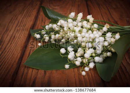 Bouquet of lilies of the valley on a background of wooden boards
