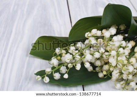 lilies of the valley on the gray wooden plank close-up