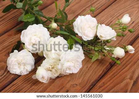 flowers white climbing rose on a wooden table