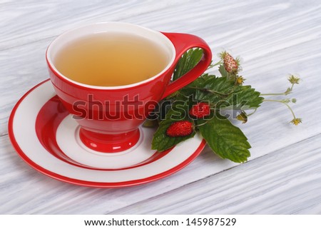 Herbal tea with berries and flowers of wild strawberries on the table