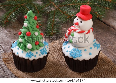 Two Christmas cupcake: Christmas tree and snowman on the table