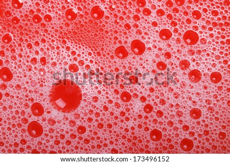 foam and soap bubbles on red background close-up. macro texture