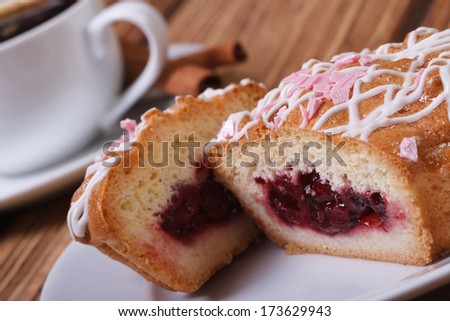 Fresh tasty sliced cake with cherry jam closeup on background of coffee with cinnamon. macro