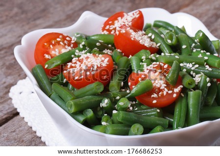 Salad of green beans, cherry tomatoes and sesame seeds on the table