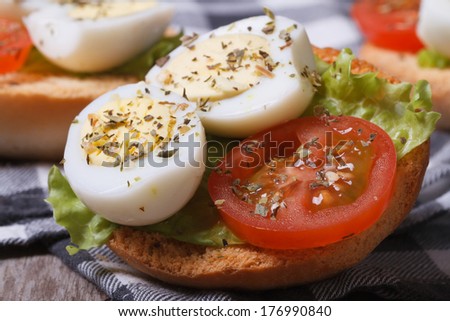 Small sandwich with quail eggs, tomato and lettuce. macro