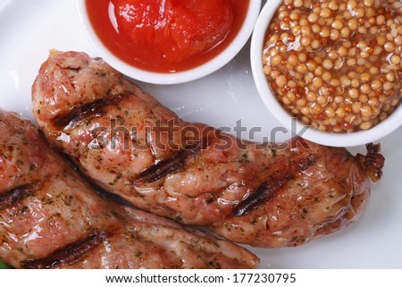 two grilled hot sausages with ketchup and Dijon mustard. closeup. top view