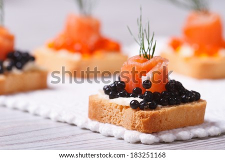 Canapes with black sturgeon caviar, smoked salmon and dill. macro. horizontal