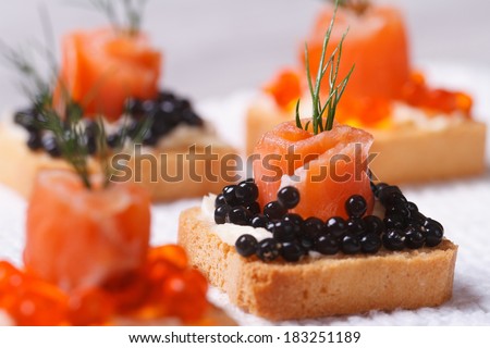 Canapes with black sturgeon caviar and salmon fish. macro. horizontal