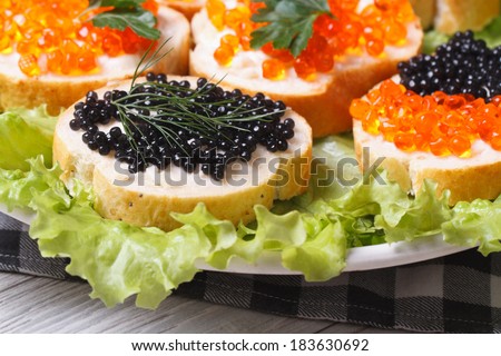 Sandwiches with red and black fish caviar on lettuce macro horizontal