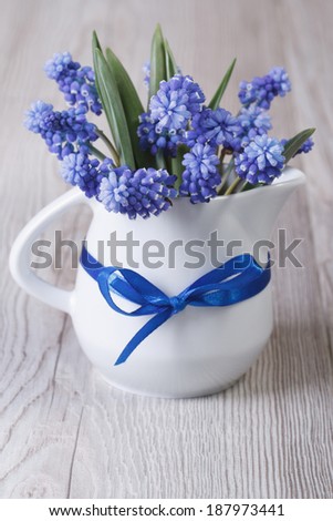 Gentle spring bouquet of blue muscari flowers in a jug on the table