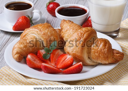 Croissants with strawberry, coffee and milk - healthy and wholesome breakfast