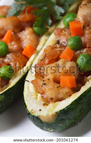 Zucchini stuffed with meat and green peas, carrot on a plate macro. vertical