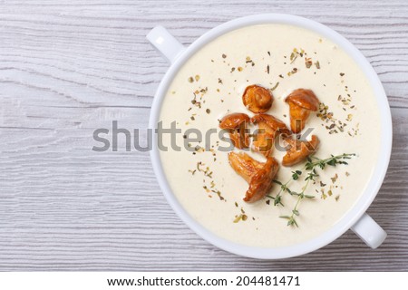 cream soup with mushrooms chanterelles and herbs on a wooden background horizontal top view
