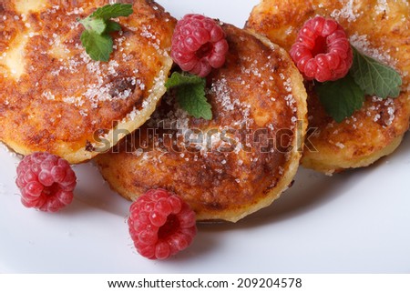 Cheese pancakes with raspberries and mint on a white plate closeup. a horizontal top view